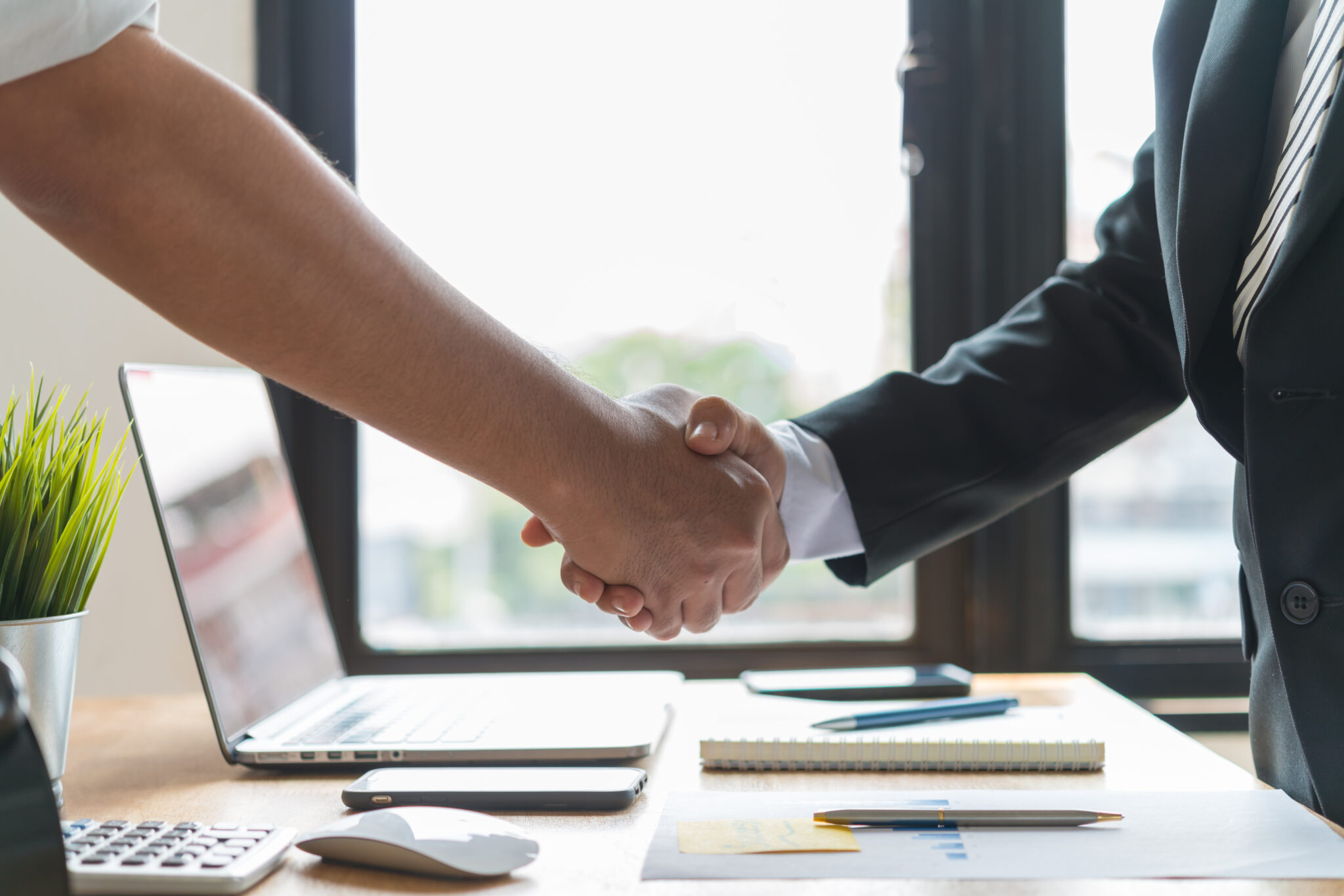 two people shaking hands to denote residential transactions